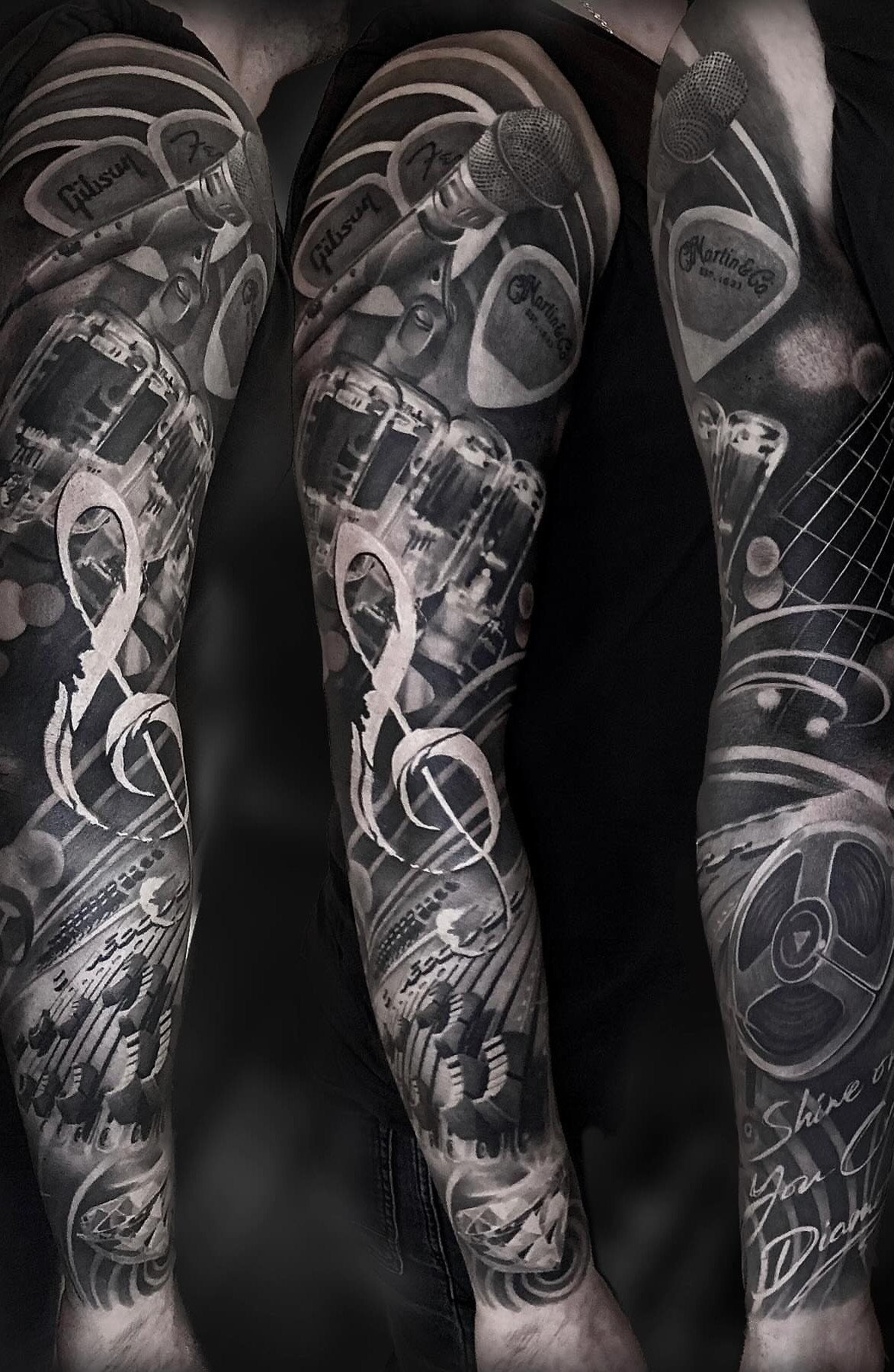 8 Arm Tattoo Filler Ideas for Sleeves That Actually Work 4 A detailed black and grey tattoo sleeve featuring musical instruments and large treble clef symbols.