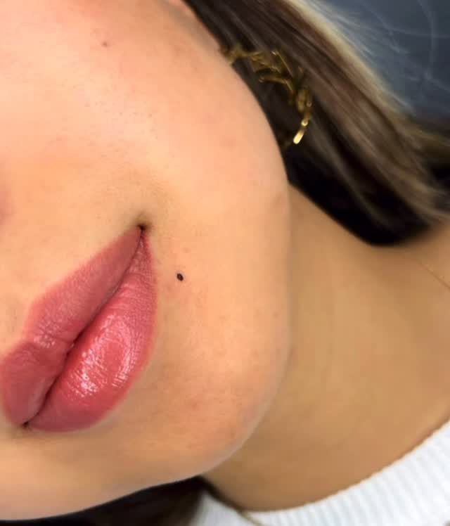 Beauty Mark Tattoo: 5 Placement Ideas for Every Face 3 A close-up of a person's face featuring a small dark beauty mark tattoo near the lips.