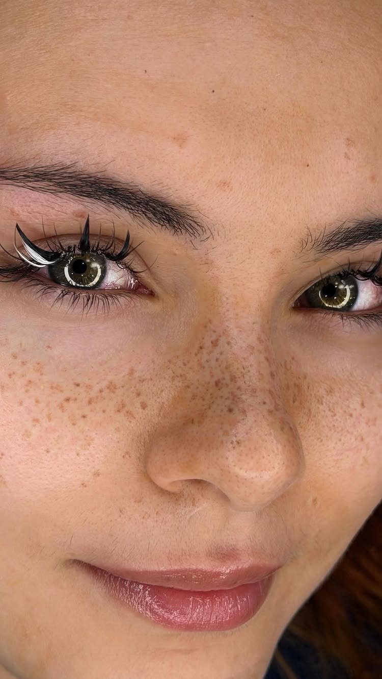 Beauty Mark Tattoo: 5 Placement Ideas for Every Face 2 Close-up portrait of a person with green eyes and prominent freckles across their nose and cheeks.