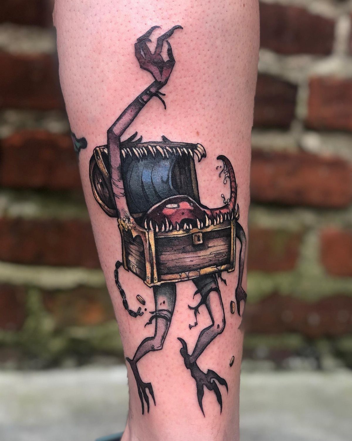 D&D Magic Tattoo Ideas: 9 Designs for Every Player 3 A colorful fantasy tattoo of a living treasure chest creature with spindly limbs on a person's leg.