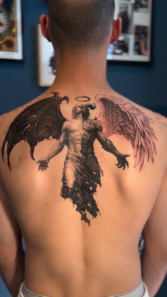 6 Evil Angel Tattoo Design Ideas and Inspiration 1 A large back tattoo of a split figure featuring both angel and demon wings.