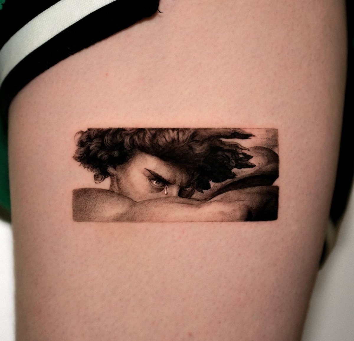 6 Evil Angel Tattoo Design Ideas and Inspiration 3 A realistic black and grey tattoo of a man's intense face on skin.