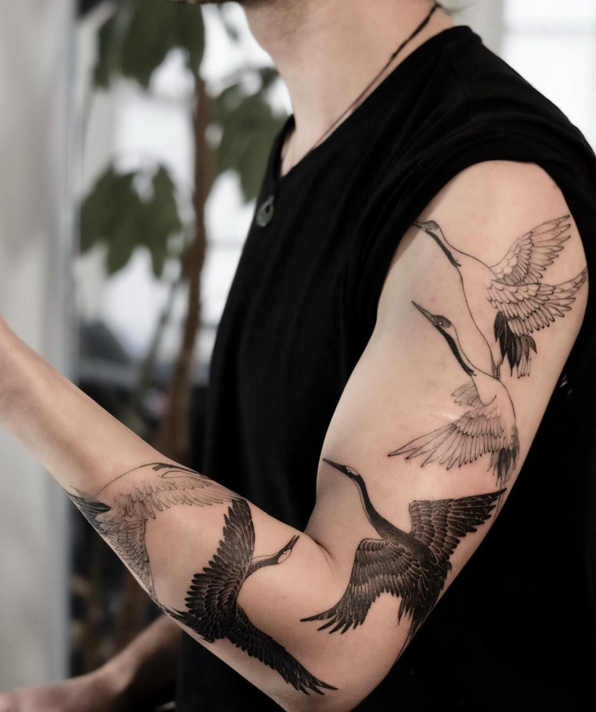 Fine Line Tattoo Sleeve: 10 Ideas With Photos 5 A person's arm displaying a fine line tattoo sleeve of several birds in flight.