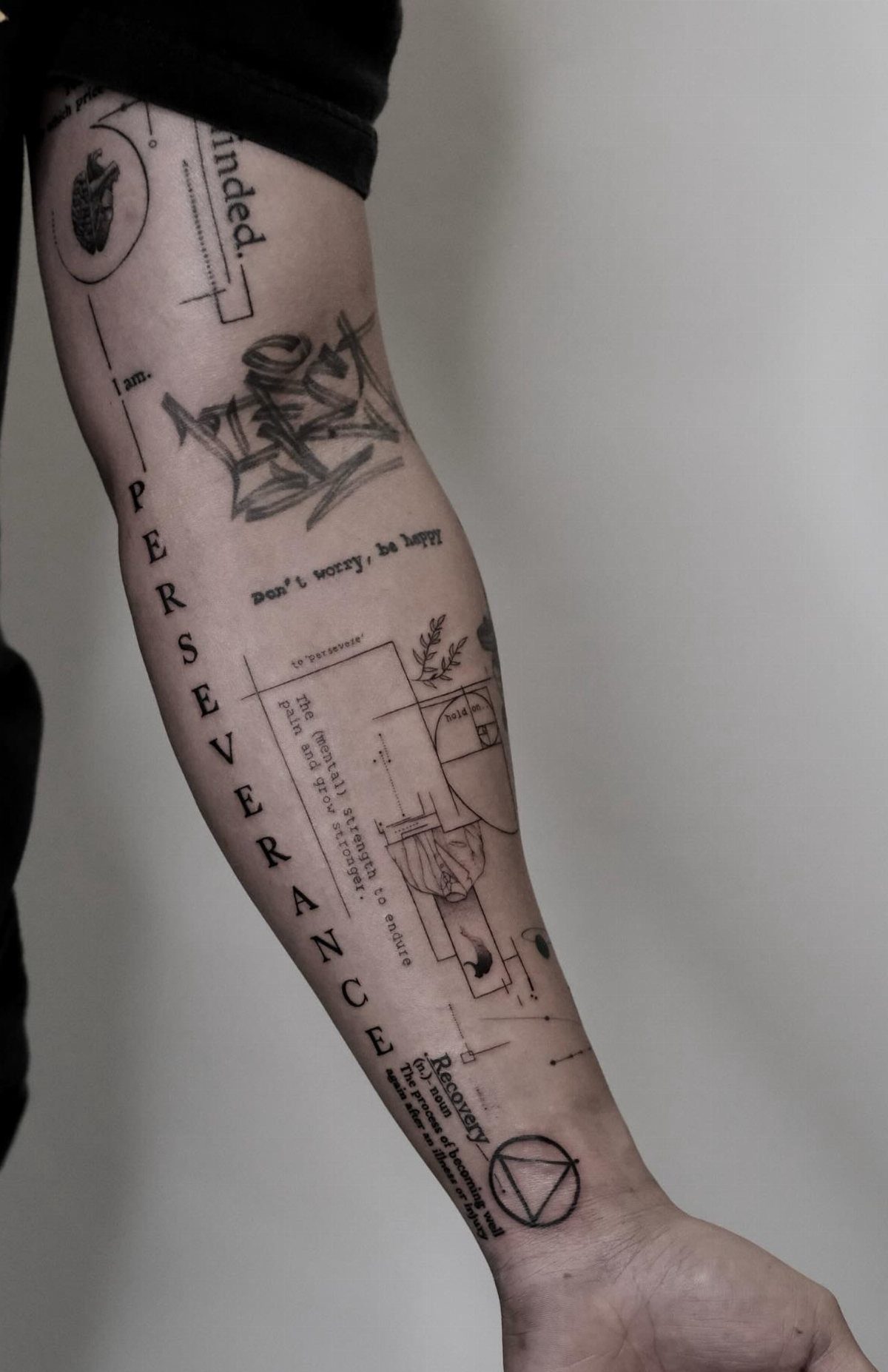 Fine Line Tattoo Sleeve: 10 Ideas With Photos 8 A person's arm displaying a complex fine line tattoo sleeve with geometric shapes and text.