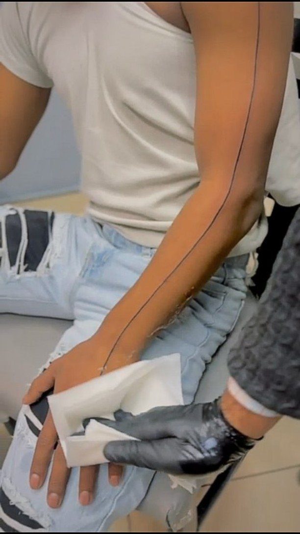 Fine Line Tattoo Sleeve: 10 Ideas With Photos 10 A person's arm with a long, single fine line tattoo running from shoulder to wrist.