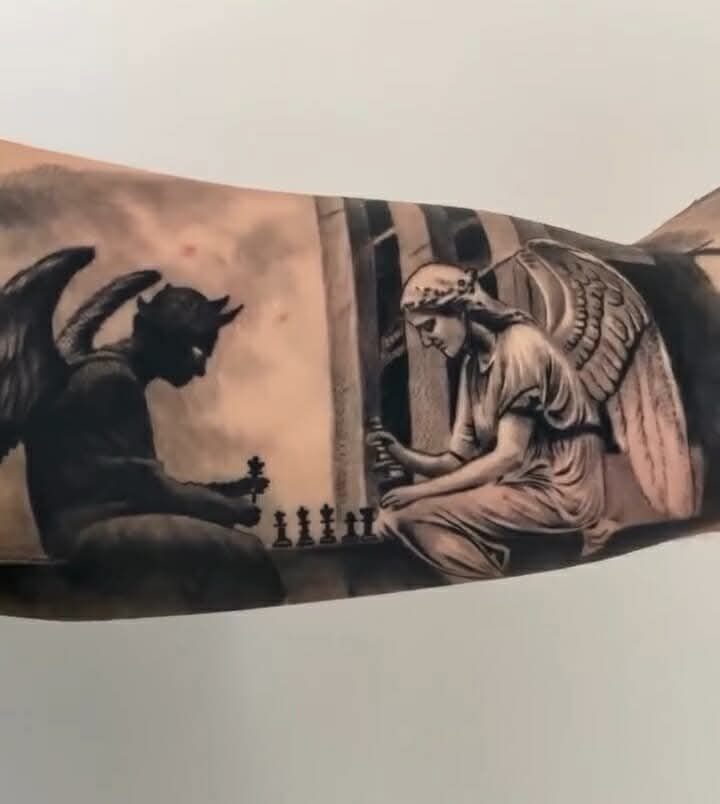 Good vs Evil Tattoo: 8 Designs That Split Skin Between Sides 3 A detailed black and grey tattoo of an angel and demon playing chess.