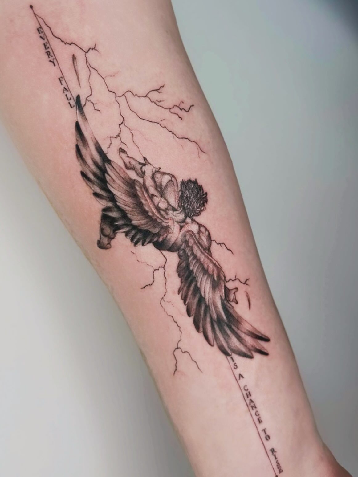 Good vs Evil Tattoo: 8 Designs That Split Skin Between Sides 4 A black and grey tattoo of a winged figure falling amidst lightning bolts on an arm.