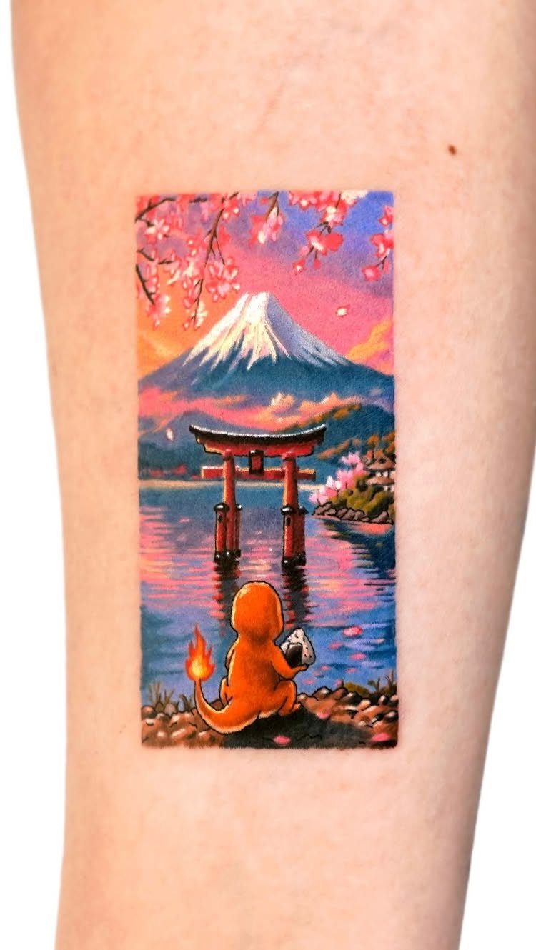 A colorful landscape tattoo on skin featuring Mount Fuji, a torii gate, and cherry blossoms.