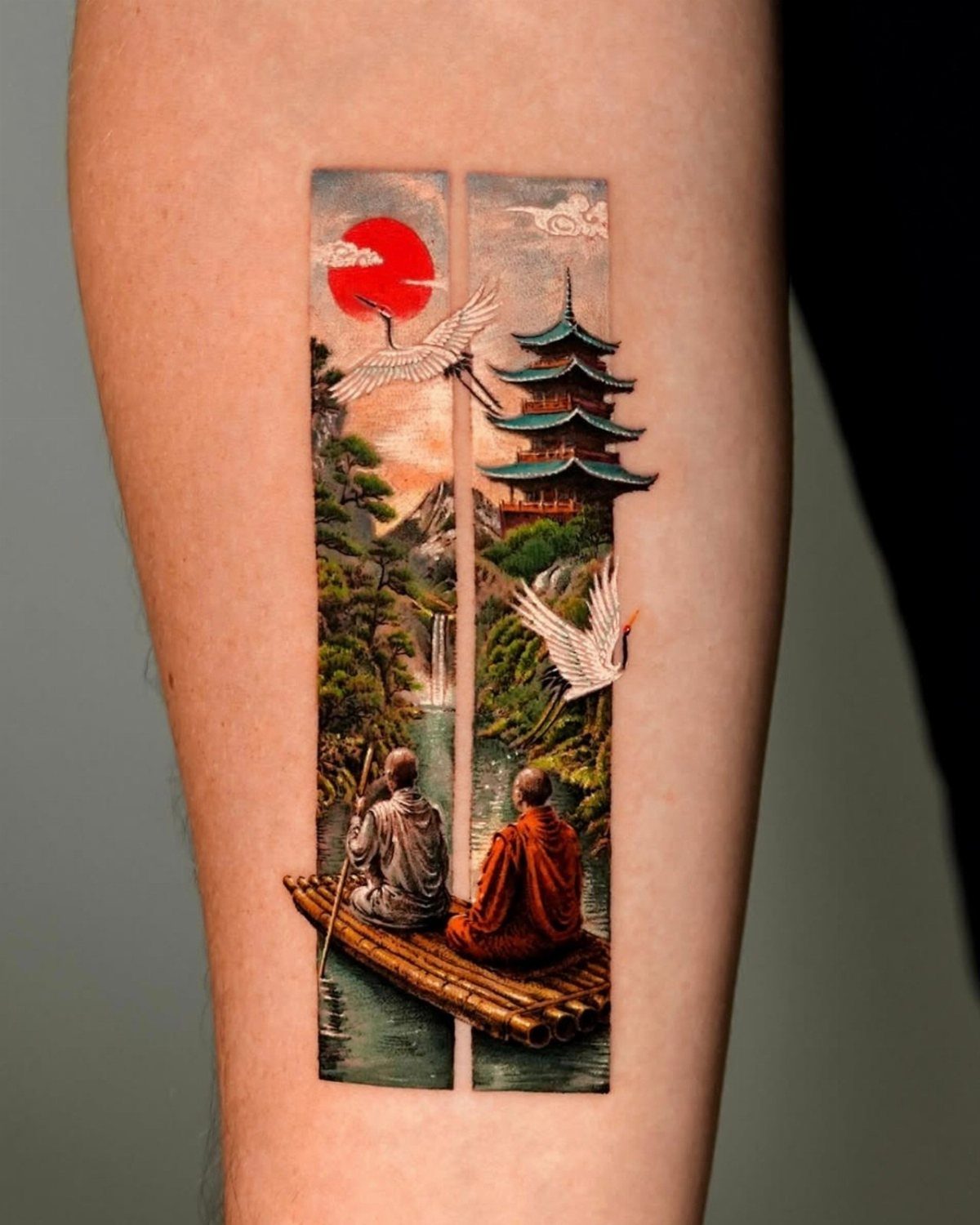 A colorful Japanese landscape tattoo on an arm featuring a pagoda, cranes, and people on a raft.