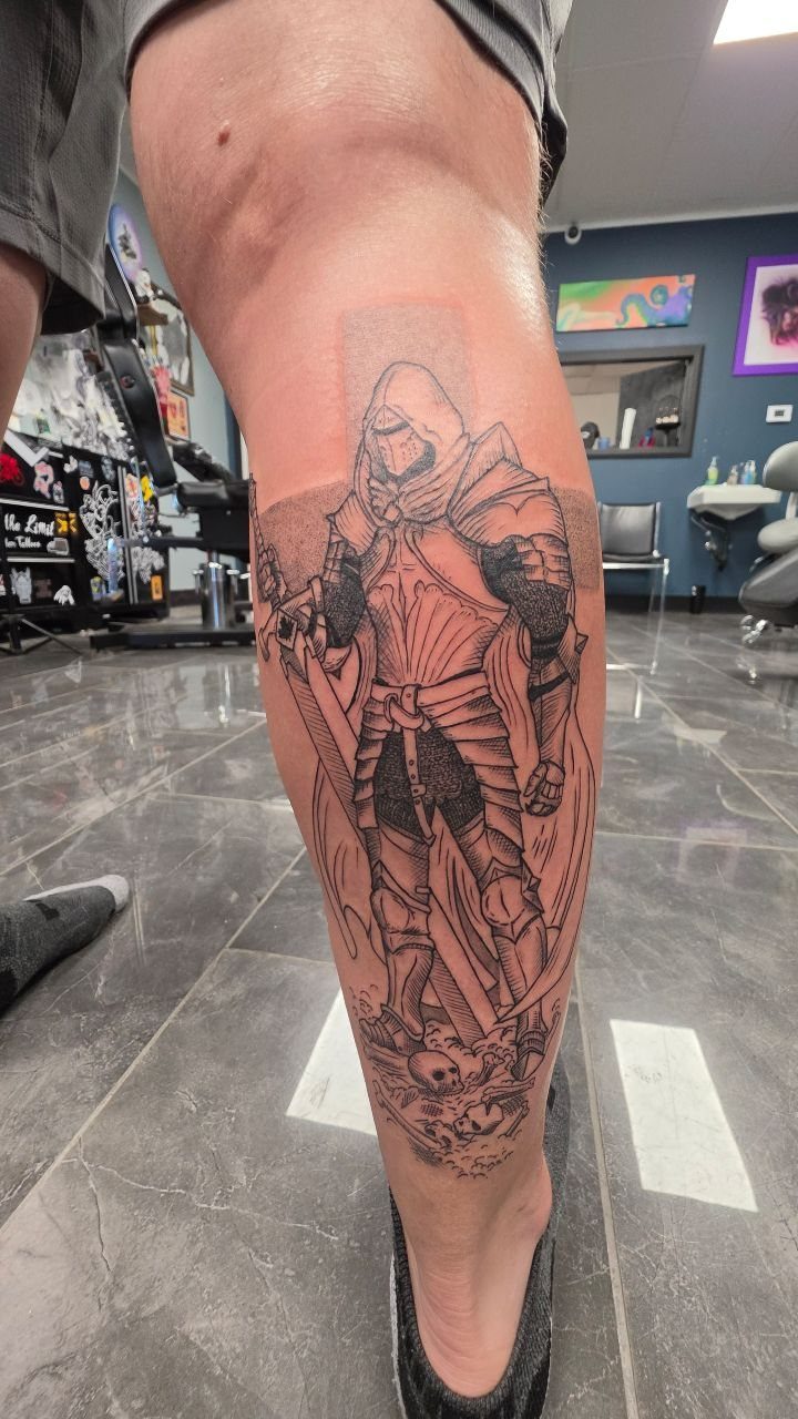 7 Knight Style Tattoo Ideas for 2026 3 A black and grey tattoo of a warrior knight in armor on a person's leg.