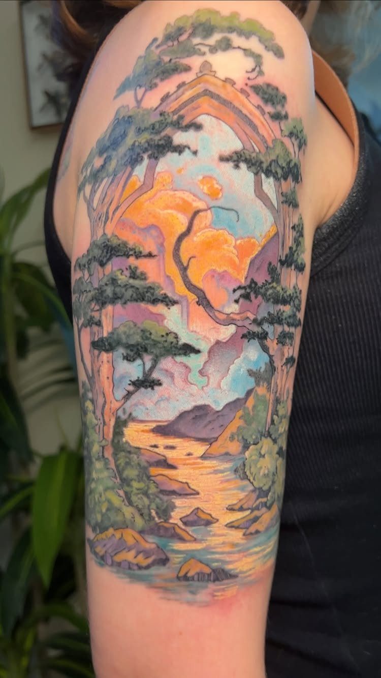 A colorful landscape tattoo on an arm featuring trees, a river, and a sunset sky.