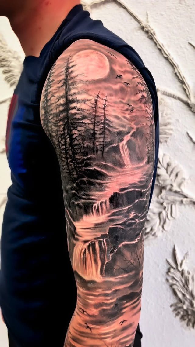 7 Landscape Tattoo Sleeve Ideas for Your Next Ink 7 A detailed black and grey tattoo sleeve depicting a forest landscape with waterfalls and a large moon.