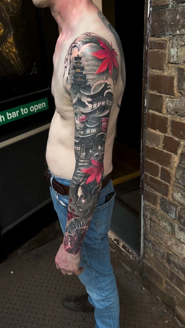 7 Landscape Tattoo Sleeve Ideas for Your Next Ink 3 A man's arm displaying a detailed Japanese landscape tattoo sleeve with a pagoda and red maple leaves.