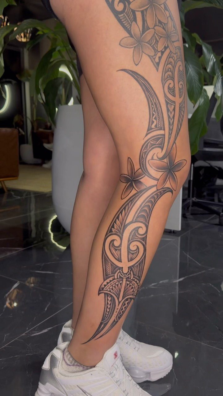 5 Leg Tattoo Template Ideas: From Printable to Full Leg Sleeve 2 A person's leg decorated with a large black tribal tattoo featuring floral and swirling patterns.