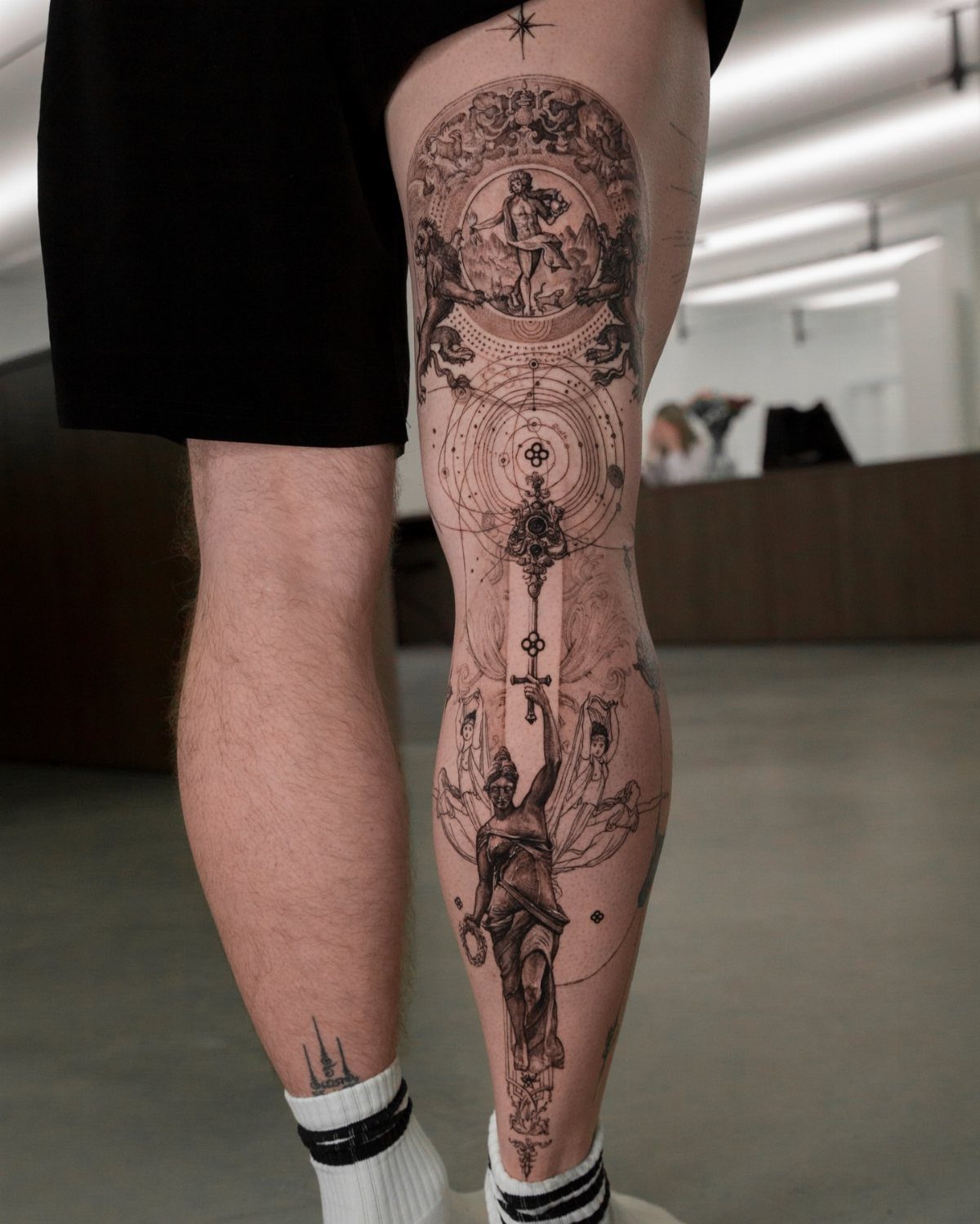 Man Leg Tattoo: 8 Styles That Fill the Canvas From Hip to Ankle 2 A person's leg decorated with large, intricate black and grey fine-line tattoos.
