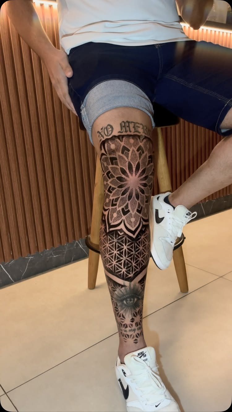 Man Leg Tattoo: 8 Styles That Fill the Canvas From Hip to Ankle 4 A man's leg displaying a large black ink geometric and mandala pattern tattoo.