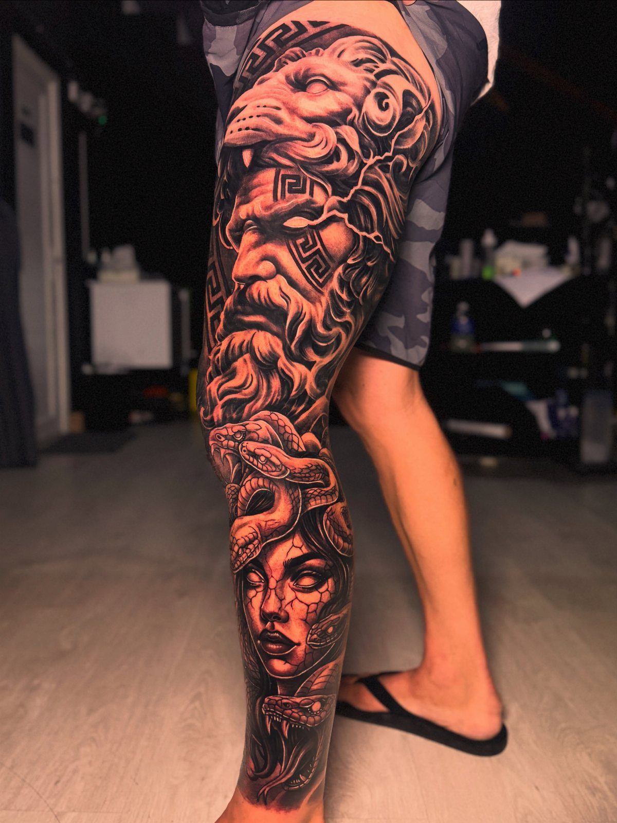 Man Leg Tattoo: 8 Styles That Fill the Canvas From Hip to Ankle 1 Large black and grey mythical creature tattoo covering a person's entire leg.