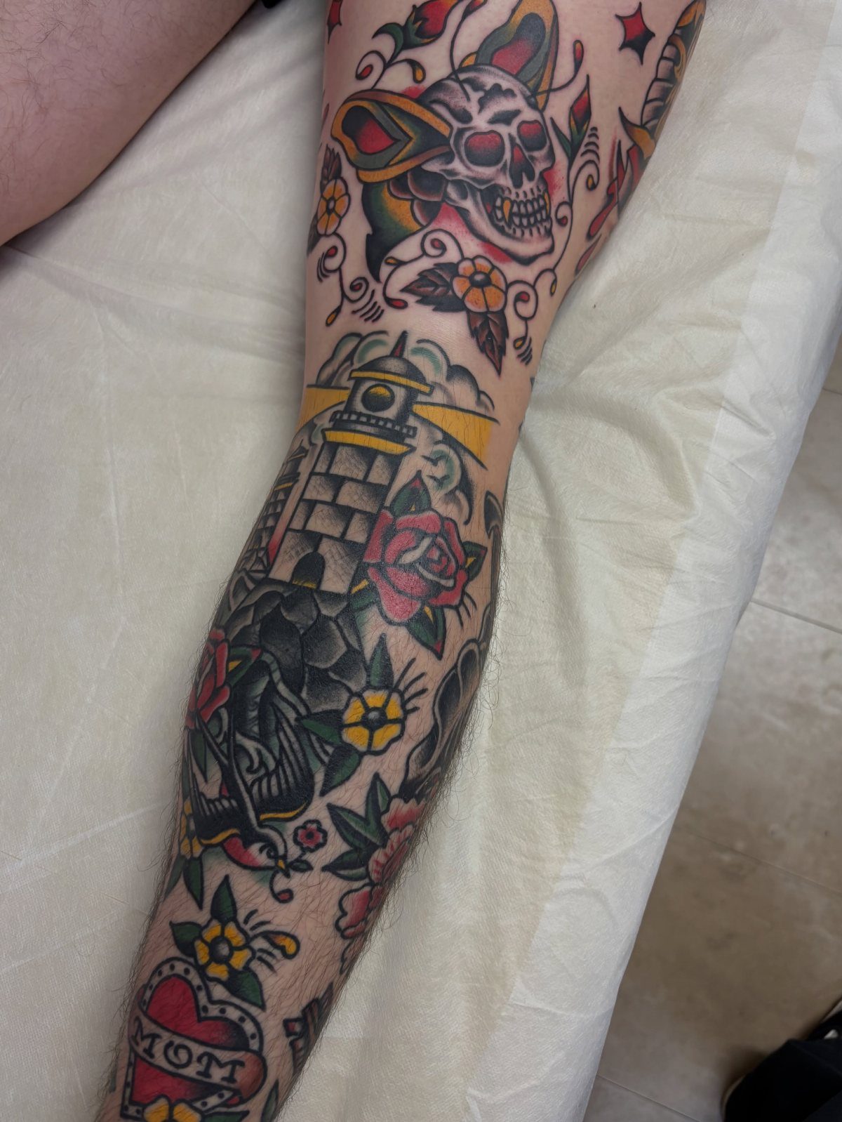 Man Leg Tattoo: 8 Styles That Fill the Canvas From Hip to Ankle 8 A person's leg covered in various colorful traditional style patchwork tattoos.