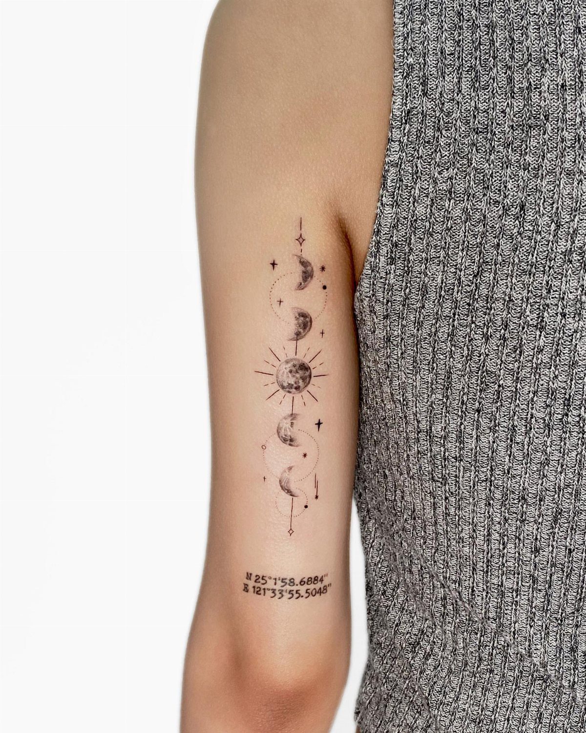 14 Minimalist Tattoo Design Ideas That Stay Simple and Clean 9 A vertical celestial tattoo on an arm featuring a sun, crescent moons, and stars in fine lines.