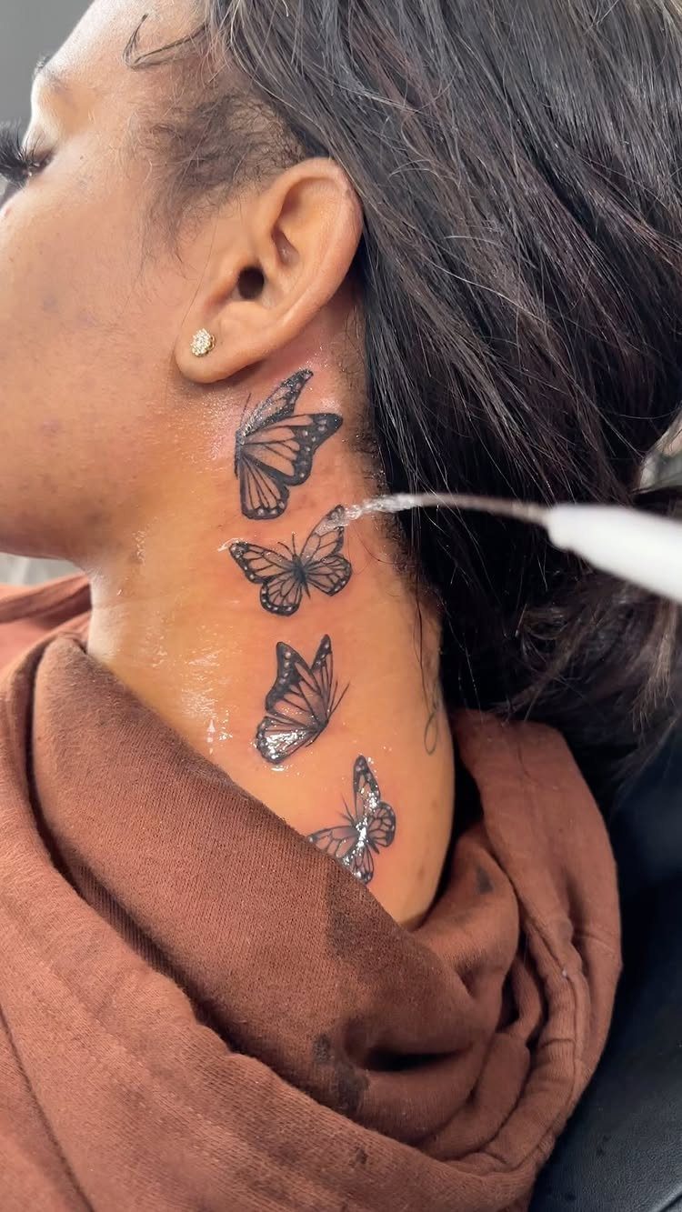 7 Neck Tattoo Designs for Women That Actually Fit the Narrow Canvas 2 Four black ink butterfly tattoos arranged vertically on a person's neck.