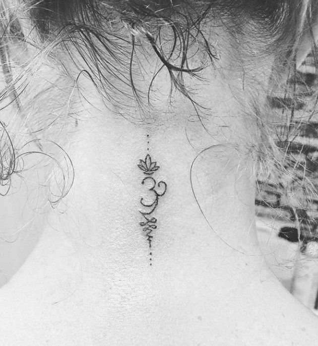 7 Neck Tattoo Designs for Women That Actually Fit the Narrow Canvas 4 A small, delicate Om symbol tattoo centered on the back of a person's neck.