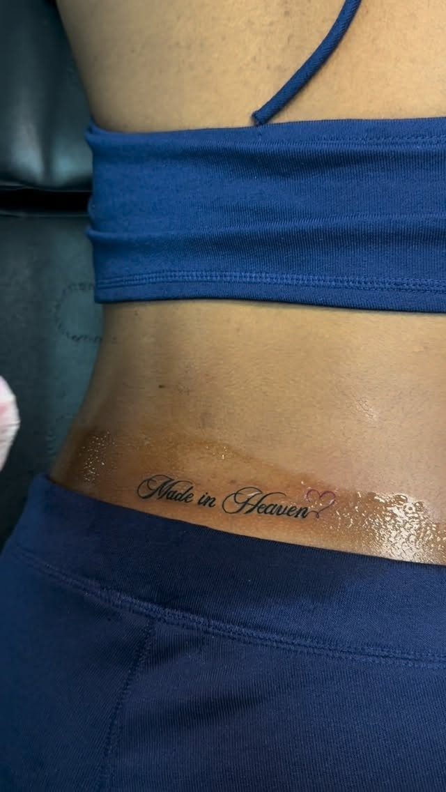 Script Tattoo Placement: 9 Positions That Work 7 A script tattoo reading Made in Heaven on a person's lower back.