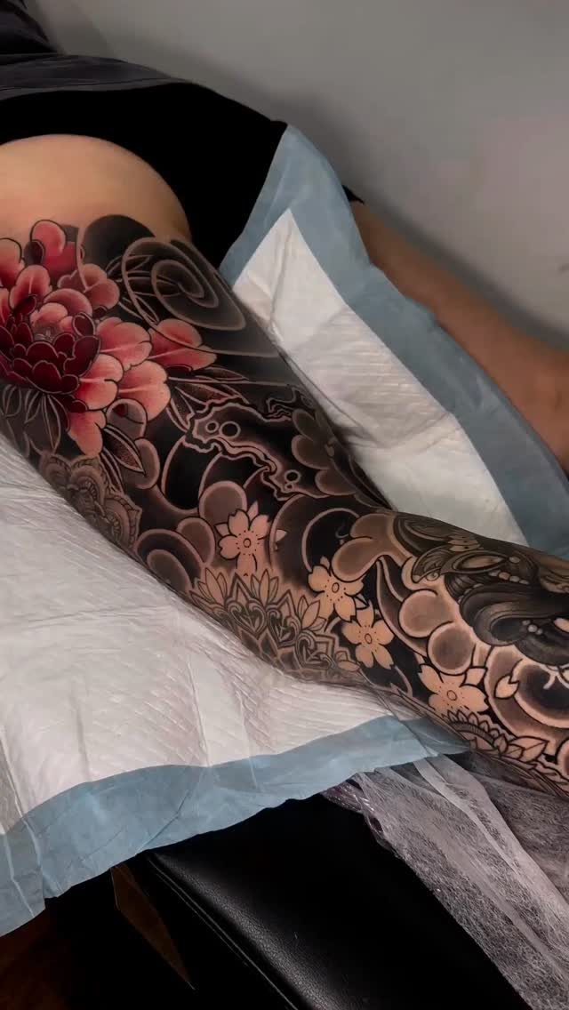 Sick Tattoo Art: 9 Styles That Redefine the Needle 4 A person's leg covered in a large, detailed Japanese style tattoo with red peonies.