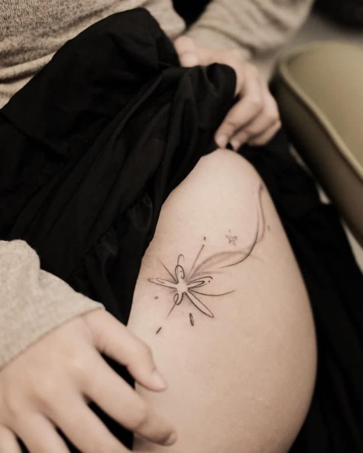 Star Tattoo on Hip: 6 Fresh Ideas for Placement and Style 5 A fine-line shooting star tattoo with wispy trails on a person's hip.