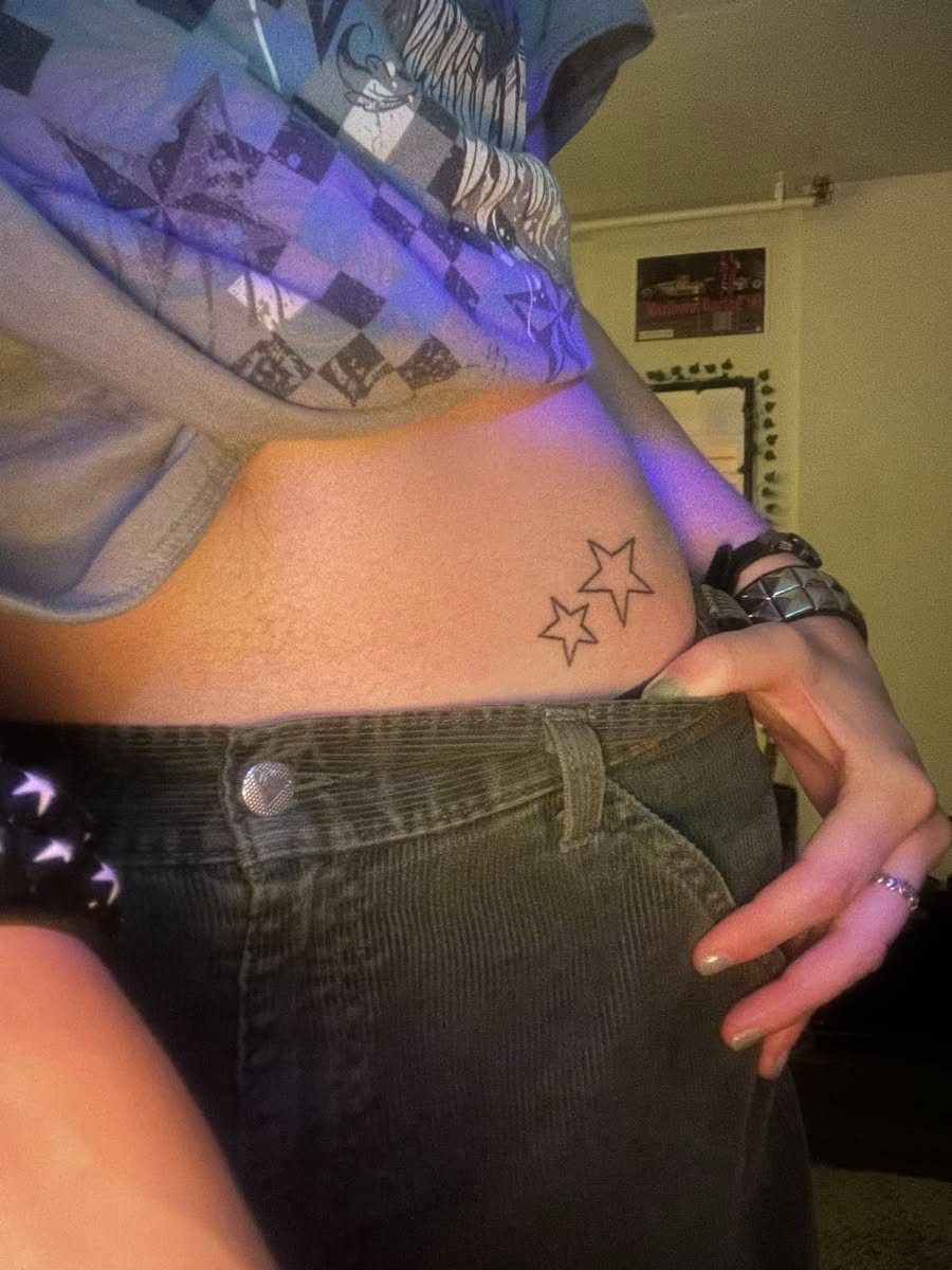 Star Tattoo on Hip: 6 Fresh Ideas for Placement and Style 3 Two small black outline star tattoos on a person's hip near their waistband.