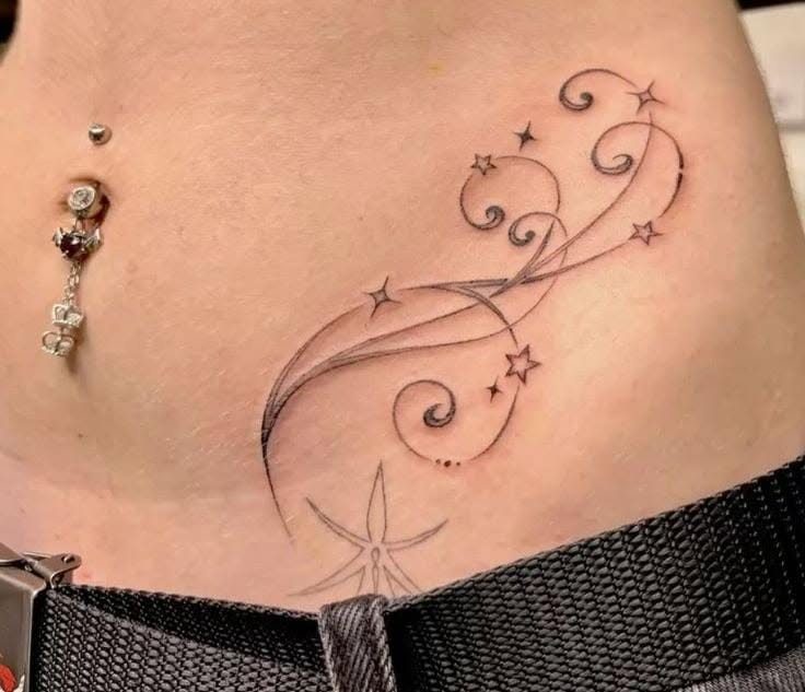 Star Tattoo on Hip: 6 Fresh Ideas for Placement and Style 2 A fine-line black ink tattoo of stars and decorative swirls on a person's hip.