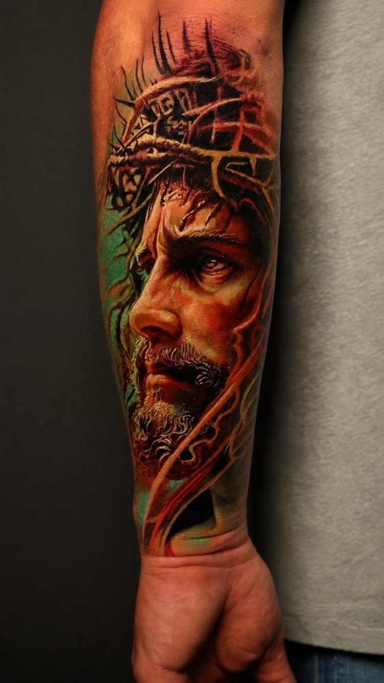 A realistic portrait tattoo of a bearded man wearing a crown of thorns on a forearm.