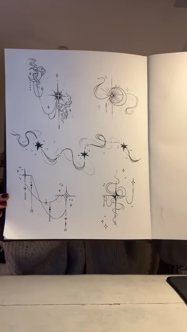 Tattoo Style Drawings: 6 Sketches Worth Keeping in Your Book 1 Black ink line art sketches of stars and flowing celestial patterns on white paper.