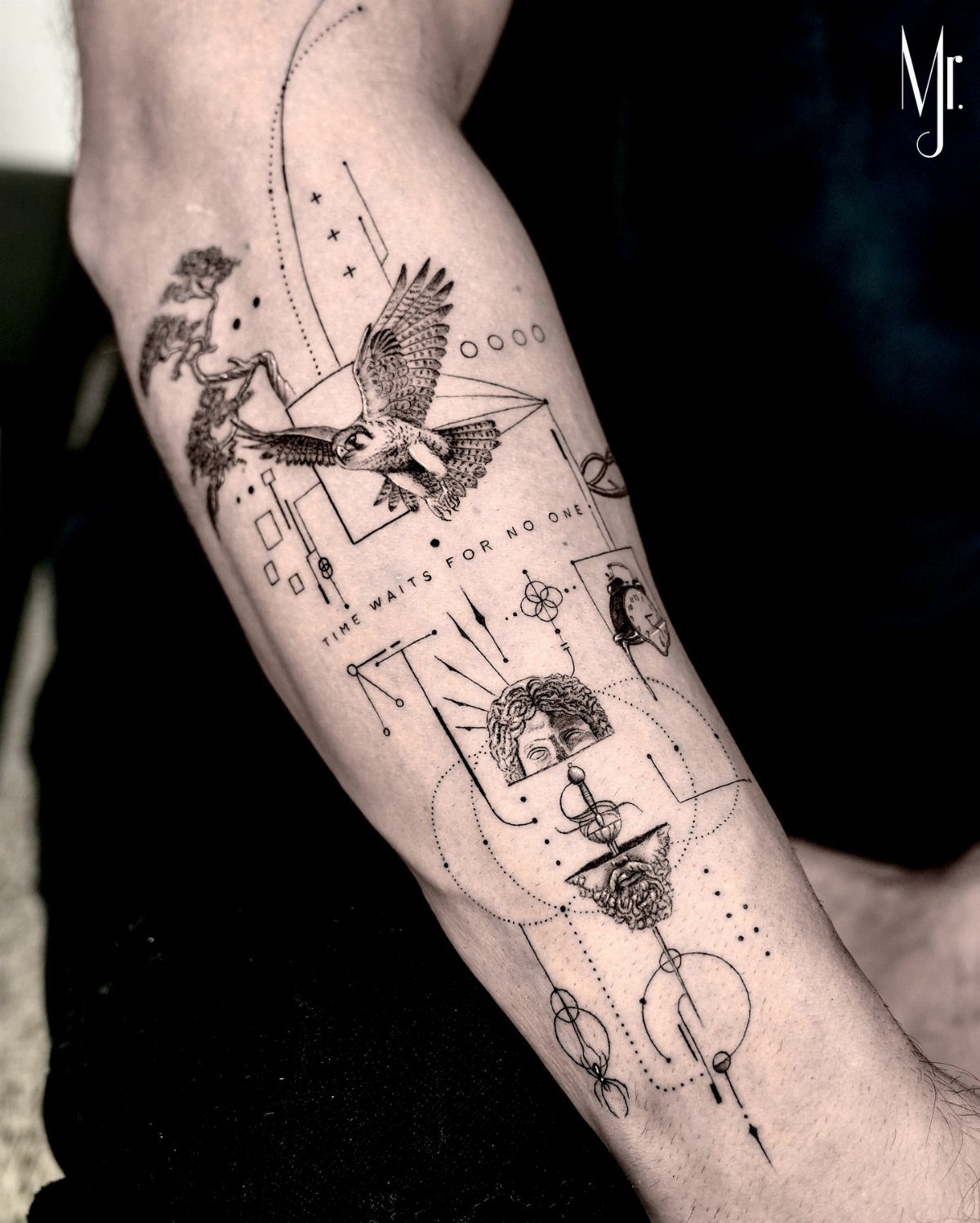 Tattoo Style Drawings: 6 Sketches Worth Keeping in Your Book 6 Black ink line art tattoo on a forearm featuring a bird, geometric shapes, and text.
