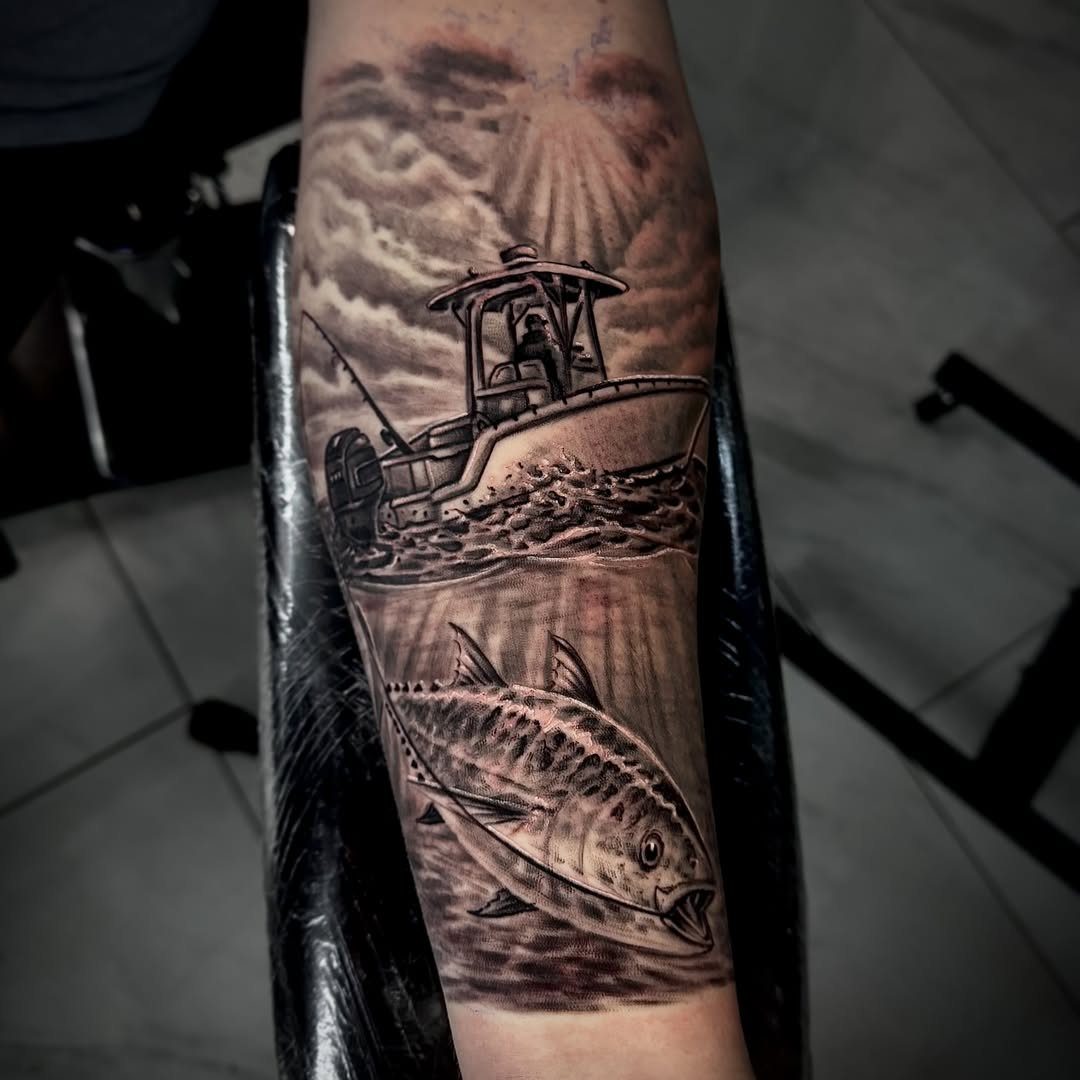 A black and grey realism tattoo on an arm depicting a fishing boat and a tuna.