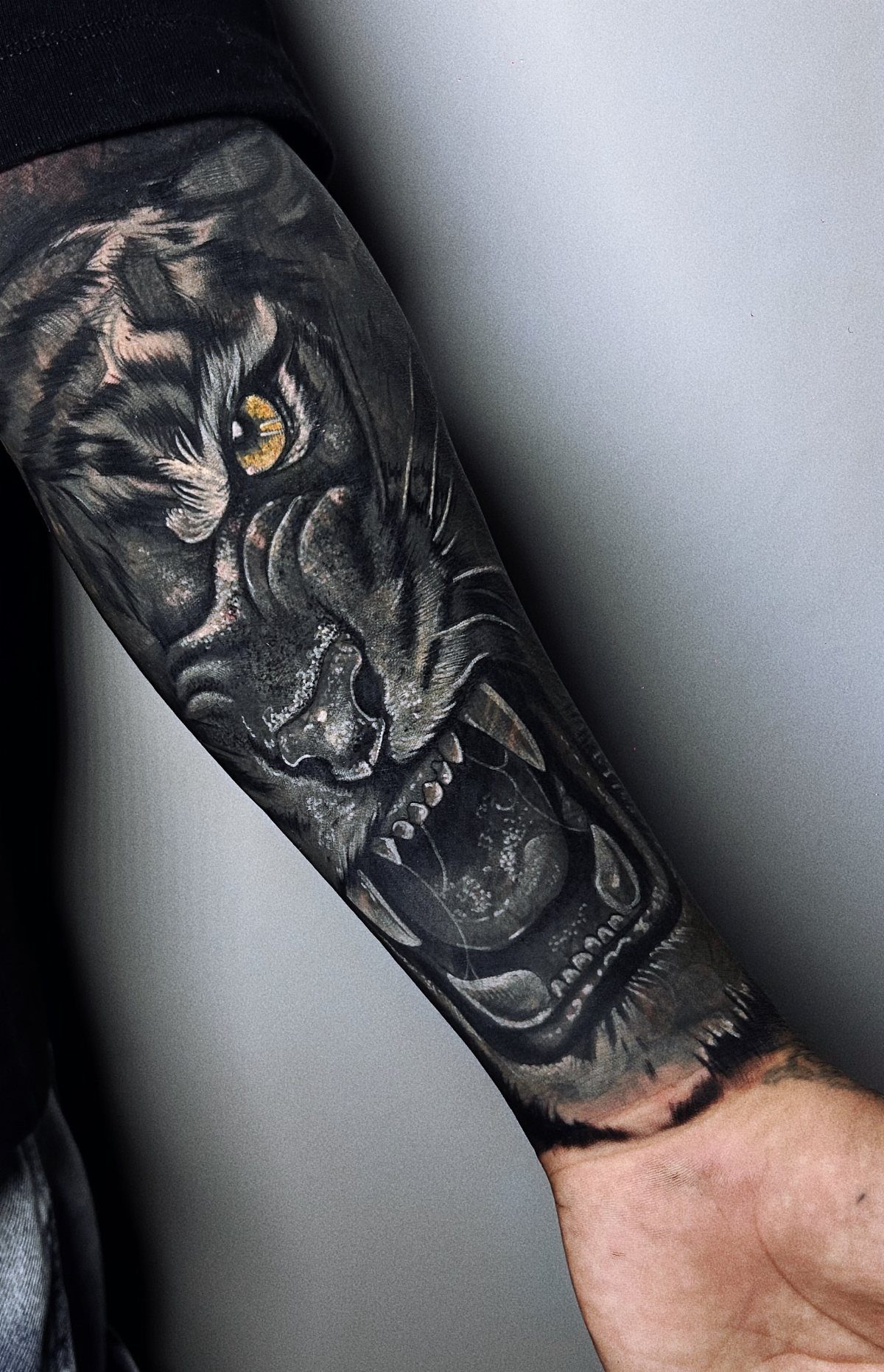 10 Traditional Cover Up Tattoo Ideas for Old Ink 7 A detailed black and grey panther tattoo covering a person's entire forearm.