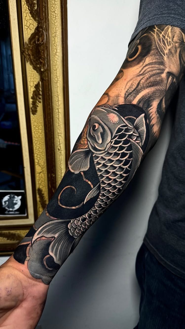 10 Traditional Cover Up Tattoo Ideas for Old Ink 8 A detailed black and grey koi fish tattoo covering a person's entire forearm and elbow.