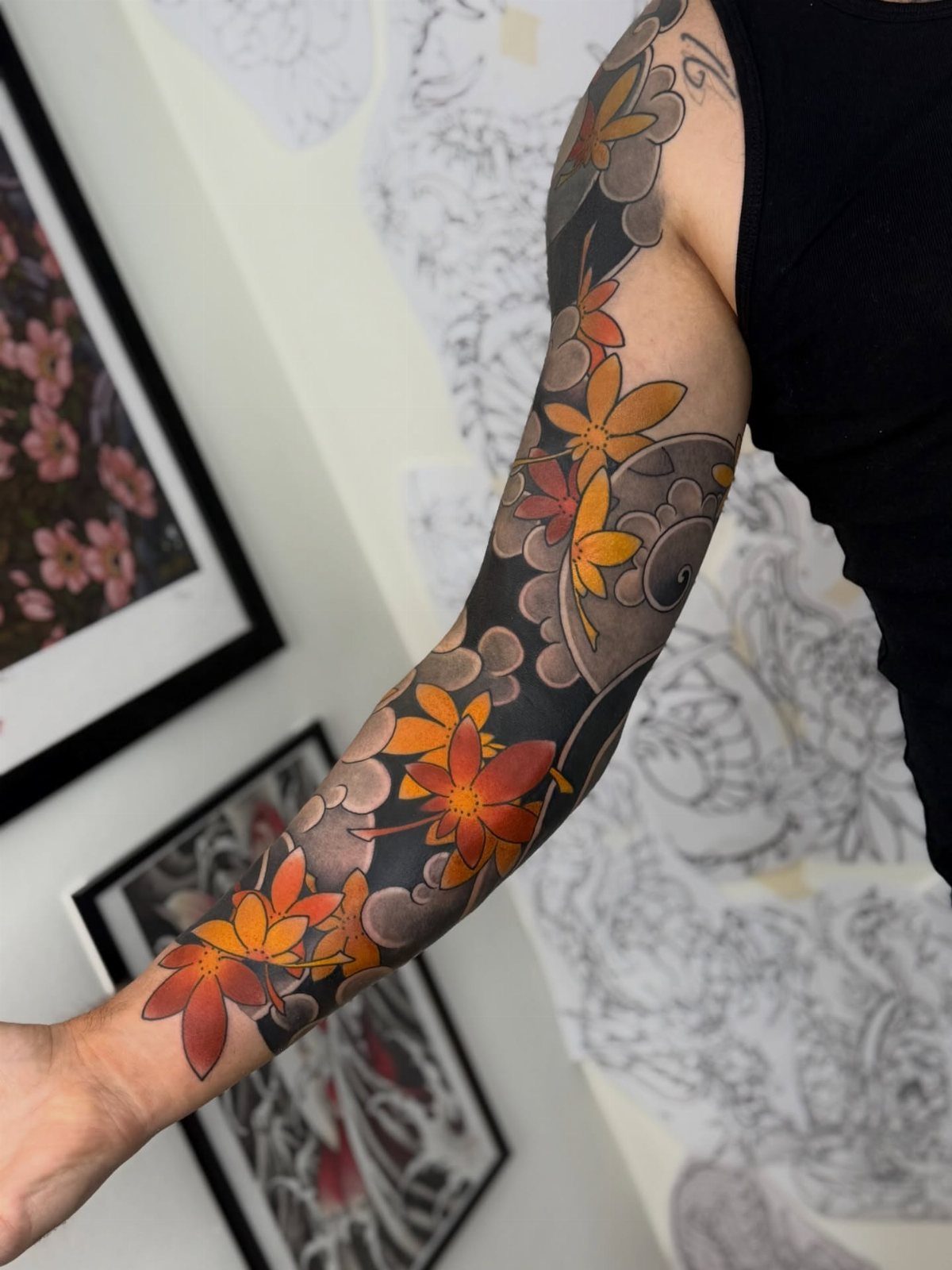 10 Traditional Cover Up Tattoo Ideas for Old Ink 6 A person's arm covered in a large, colorful traditional Japanese floral tattoo.