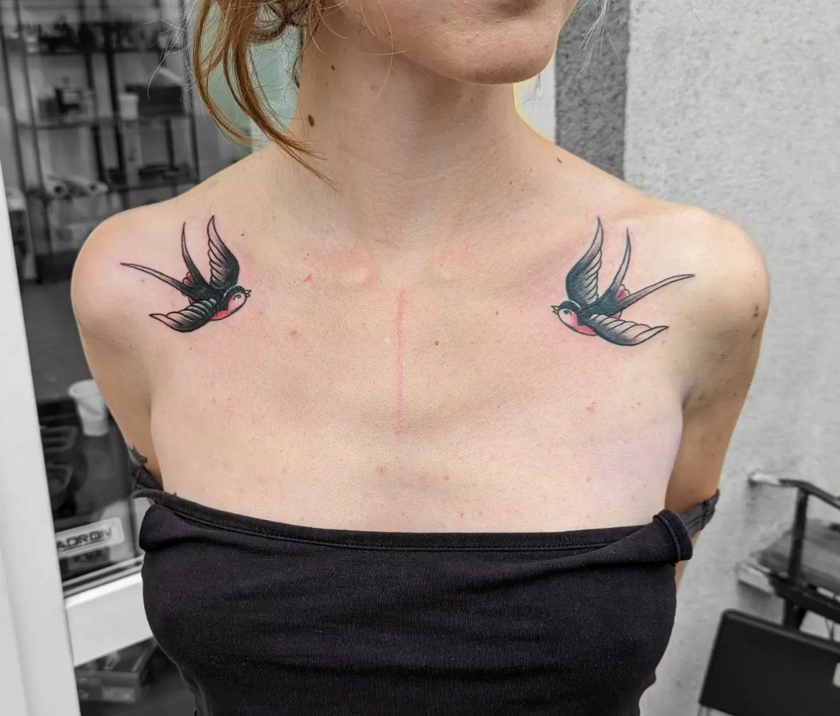 10 Traditional Cover Up Tattoo Ideas for Old Ink 5 Two traditional swallow tattoos on a person's collarbone area.