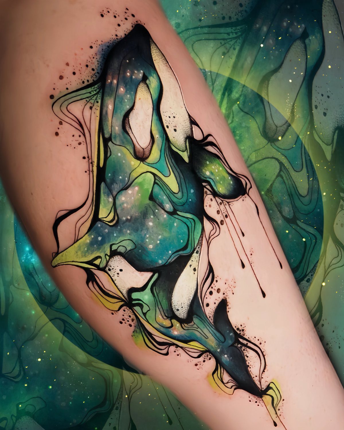 Universe Tattoo Pattern: 8 Space-Inspired Designs for Your Next Ink 8 A colorful orca tattoo on an arm featuring swirling teal, green, and yellow patterns with star-like dots.